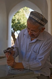Stonemason chiselling a grave stone