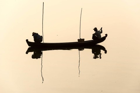 Fishermen in their boat in the morning light
