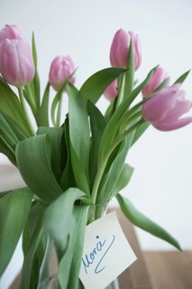 Tulips in a vase with the note 'Merci'