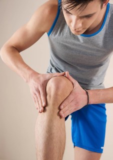 Young man examining his knee