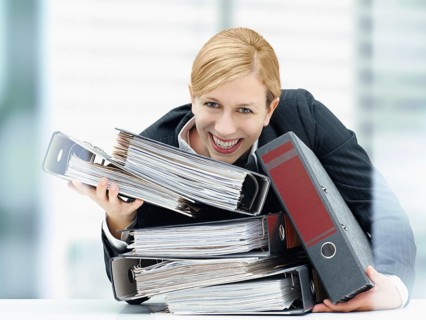 Smiling business woman holding a stack of folders