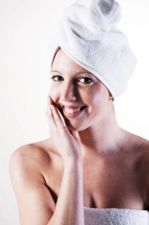 Portrait of a smiling young woman with a towel wrapped around her head