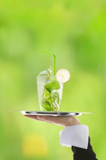 Hugo cocktail with lime and mint being served on a tray