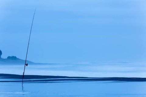 Fishing rod on the beach at dusk