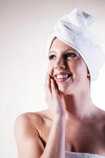 Portrait of a smiling young woman with a towel wrapped around her head