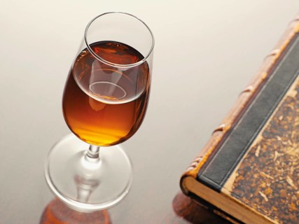 Glass of sherry beside an old book