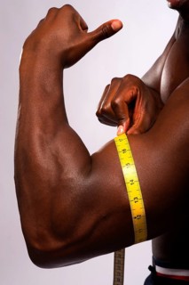 Man measuring his biceps with a tape measure
