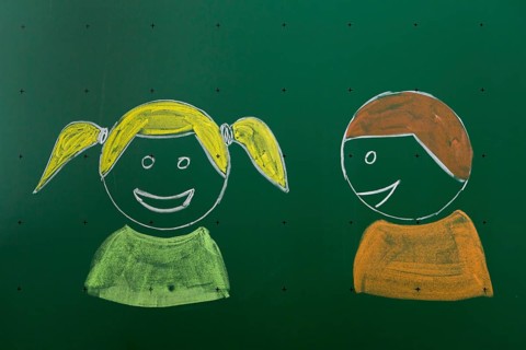 Two children drawn with chalk on a blackboard