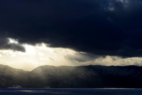 Sun breaks through the clouds at the frozen Lake Kussharo