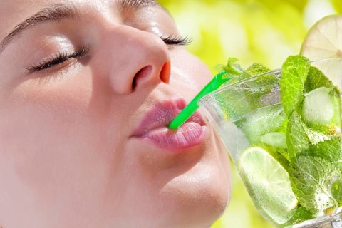 Woman drinking a Hugo cocktail with lime and mint