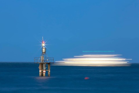 Evening mood with a with moving ship at the Hoernle Lighthouse