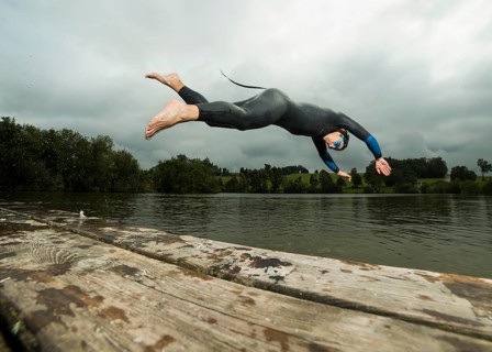 Triathlete diving into Aichstruter Reservoir