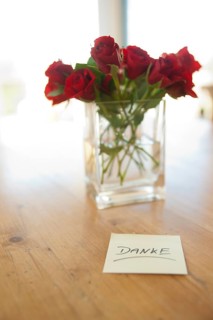 Red roses in vase with the note 'danke'