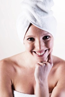 Portrait of a smiling young woman with a towel wrapped around her head