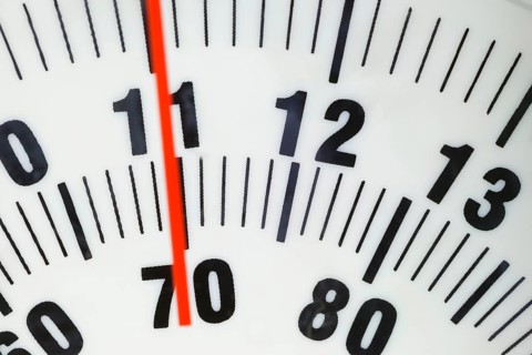 Bathroom scale indicating 70 kilograms or 11 stone