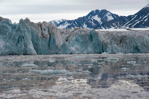 Green shimmering glacier front of Kongsbreen