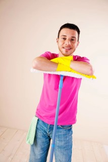 Smiling man leaning on a mop