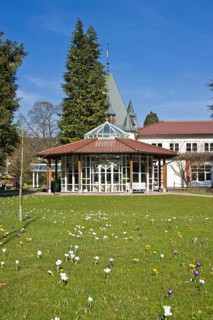 Historic Kurhaus with a pavilion and crocuses in the lawn