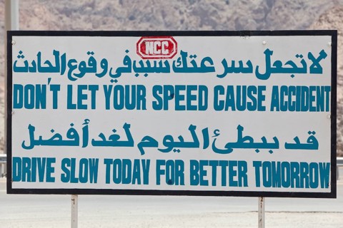 Bilingual grammatically wrong road sign in Arabic and English 'Do not let your speed cause accident
