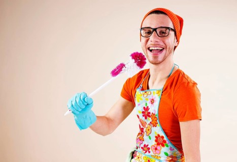 Young man holding a toilet brush in his hand while doing the housework