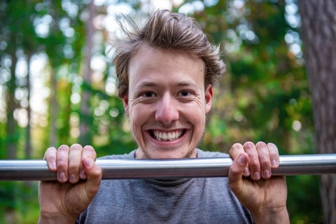 Young man doing pull-ups on a pull-up bar