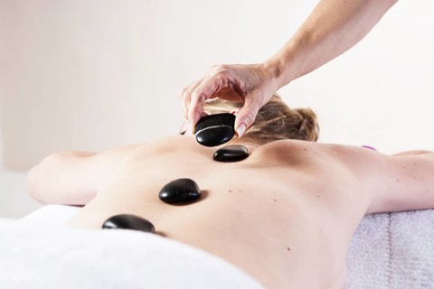 Young woman being treated with hot stones