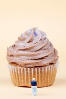 Miniature figurine standing in front of muffin
