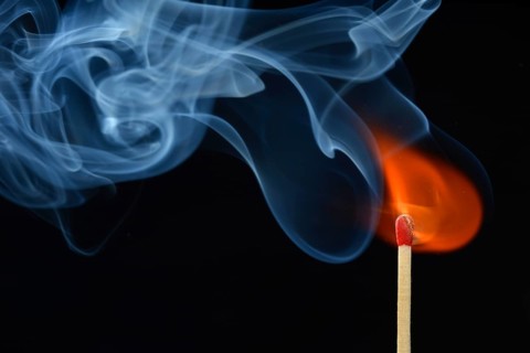 Lit matchstick with a flame and smoke