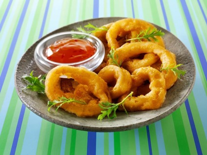 Deep fried breaded onion rings with chili sauce and salad