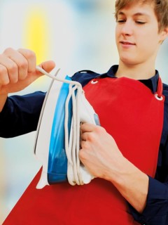 Young man wearing an apron while doing the housework