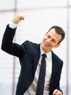 Businessman in an office cheering with a clenched fist