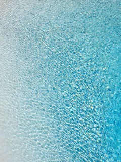 Slightly ruffled turquoise-coloured surface of water in a swimming pool