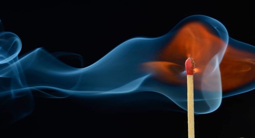 Lit matchstick with a flame and smoke