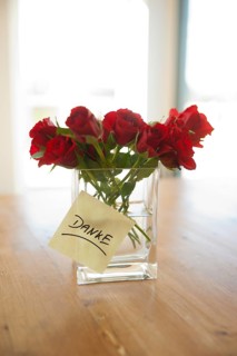 Red roses in vase with the note 'danke'