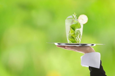 Hugo cocktail with lime and mint being served on a tray