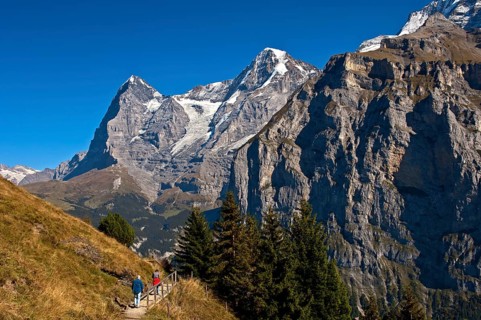 Hikers at the foot of Eiger and Moench Mountains and Eiger glacier