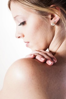 Young woman looking over her bare shoulder
