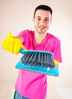 Man holding a hand brush and a dustpan