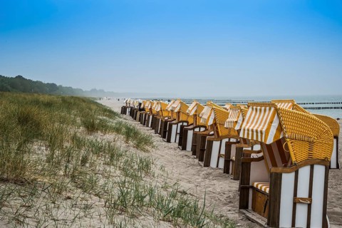 Roofed wicker beach chairs on the beach
