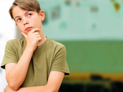 Schoolboy looking thoughtful in a classroom