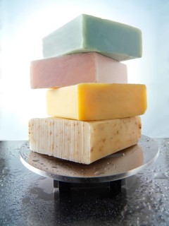 Bars of hand-made soaps piled on a soap dish