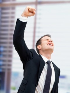 Businessman in an office cheering with a clenched fist