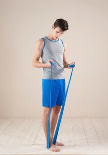Young man doing fitness exercises with a resistance band