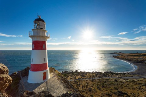 Cape Palliser Lighthouse overlooking Kirikiri Bay on the Cook Strait at sunset