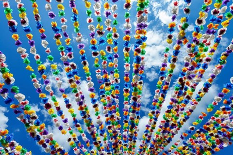 Colourful paper garlands against a blue sky