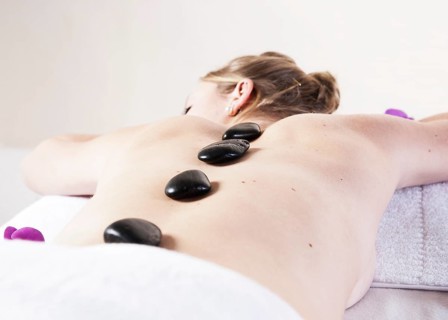 Young woman being treated with hot stones