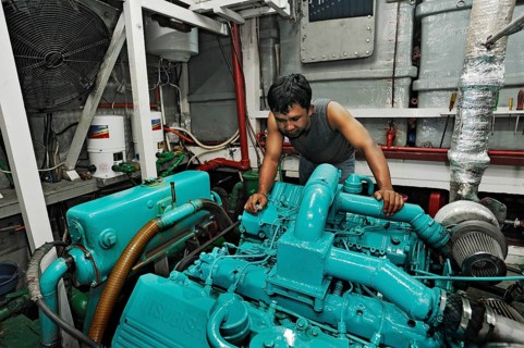 Machine operator in the engine room on the Buginese Schooner