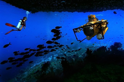 Scuba diver and a submarine in an underwater cave