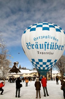 White and blue hot air balloon with advertising of 'Herzogliches Braeustuebel' restaurant