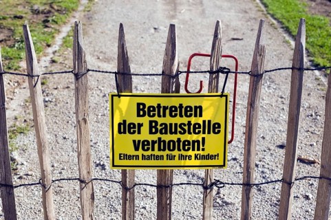 Sign on a picket fence 'Betreten der Baustelle verboten!'